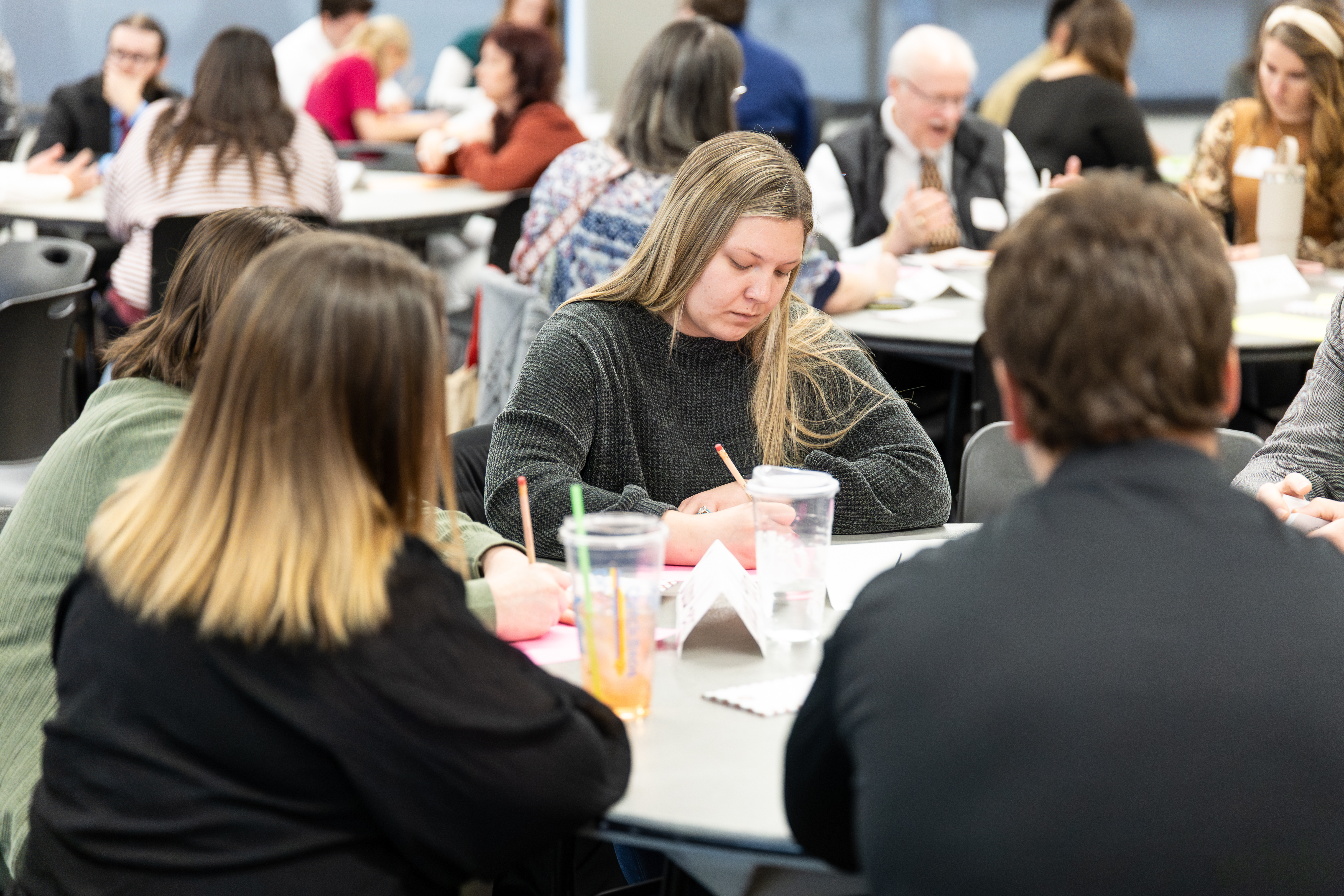 An educator takes notes at a table during the rural schools summit