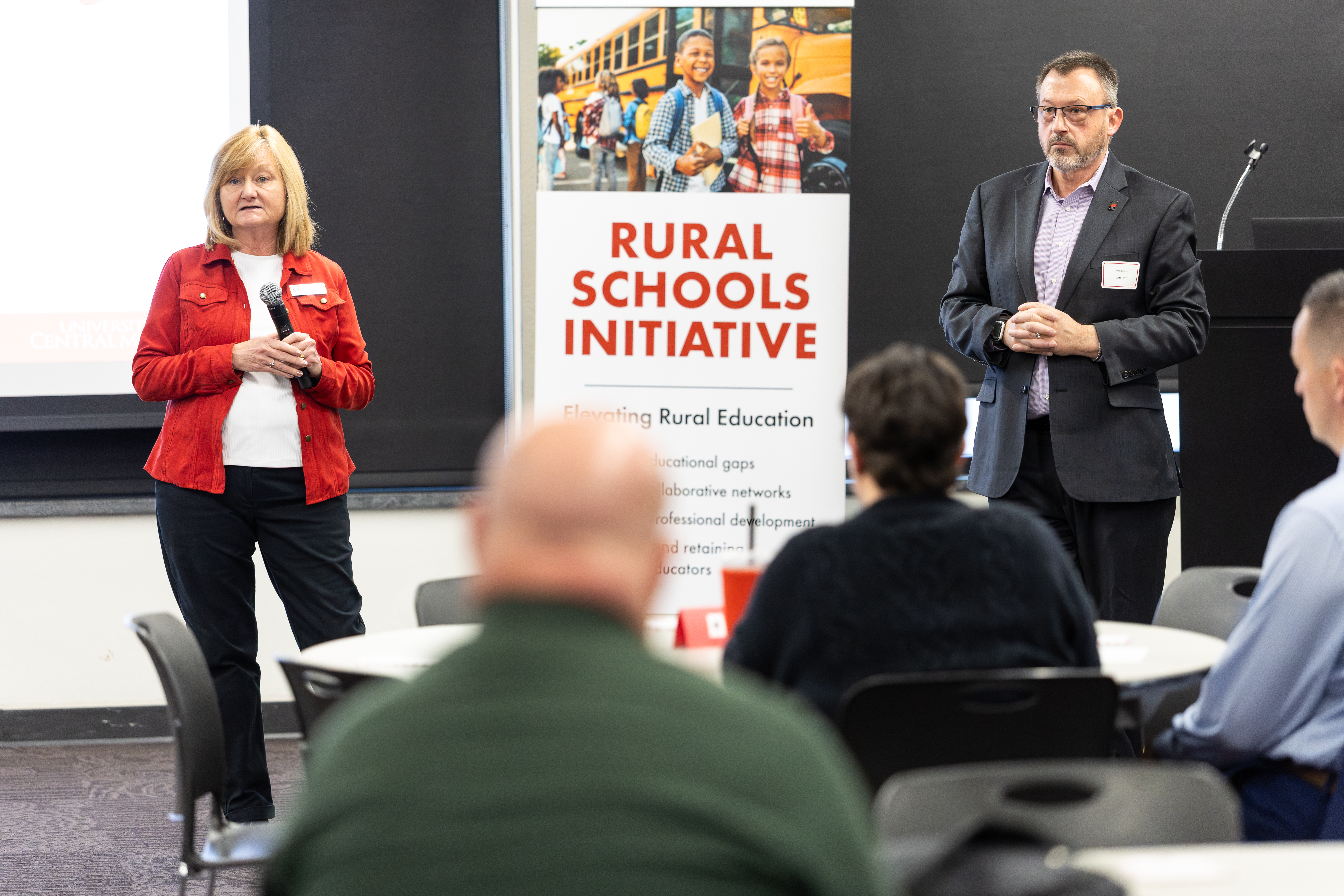 Two educators present at the front of the room at the spring rural schools summit