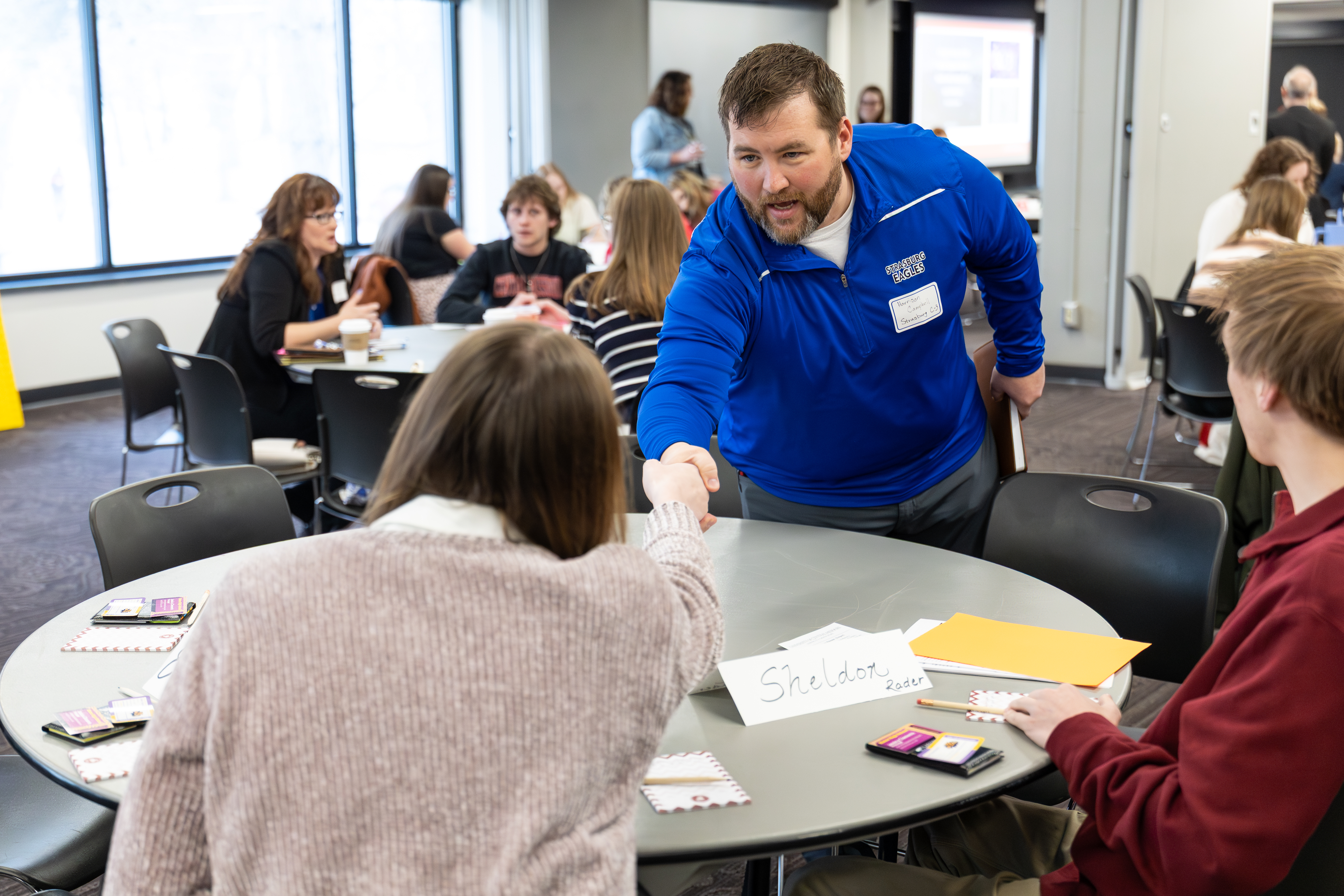 Two educators shake hands at the 2026 rural schools summit