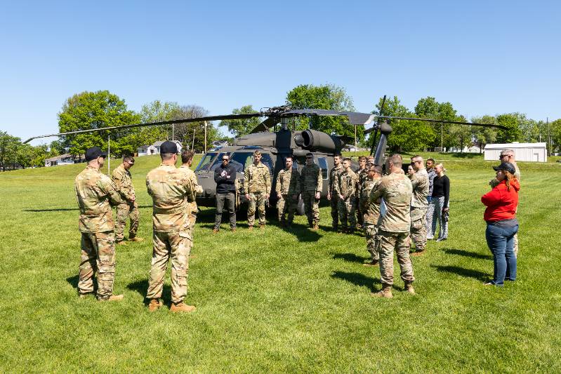 Cadets with blackhawk helicopters in the background