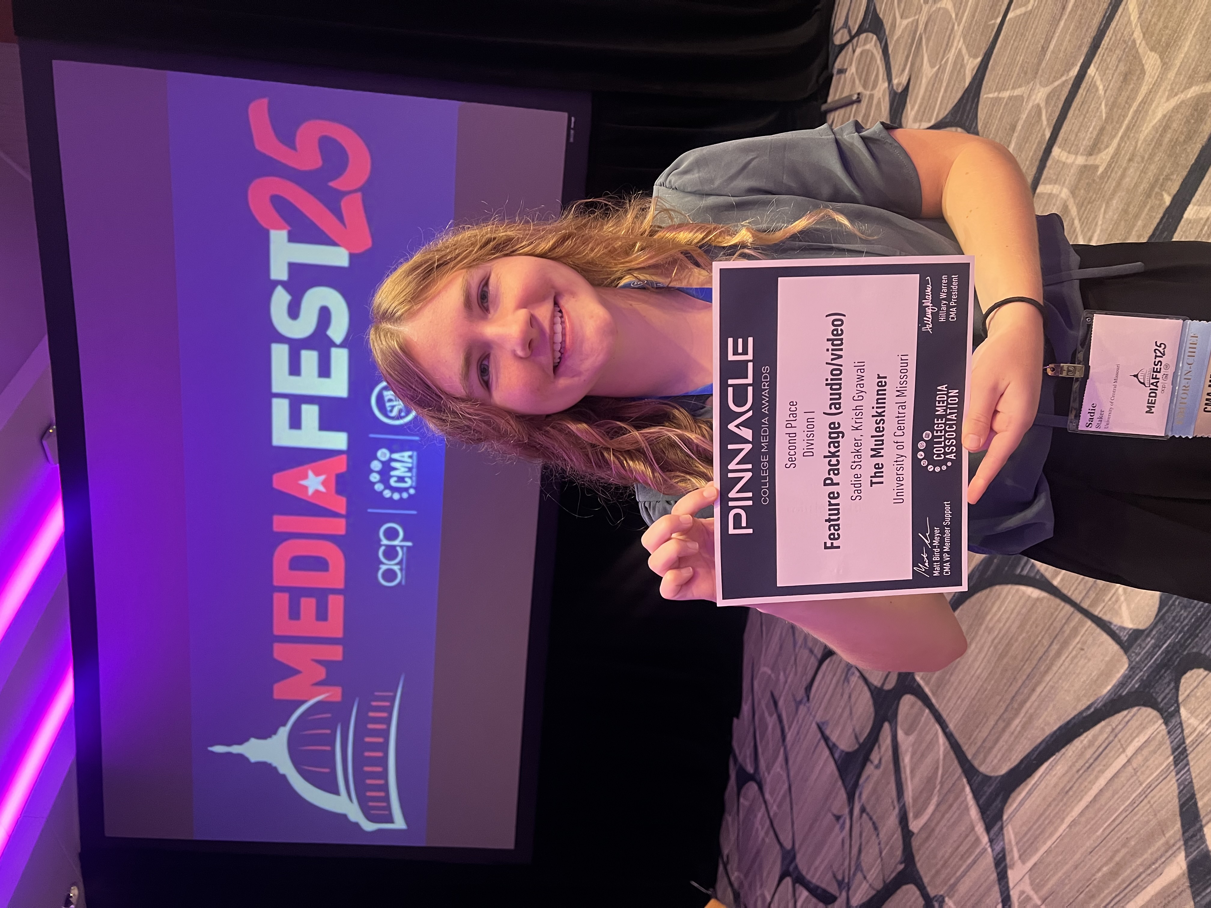 Sadie Staker holds an award certificate