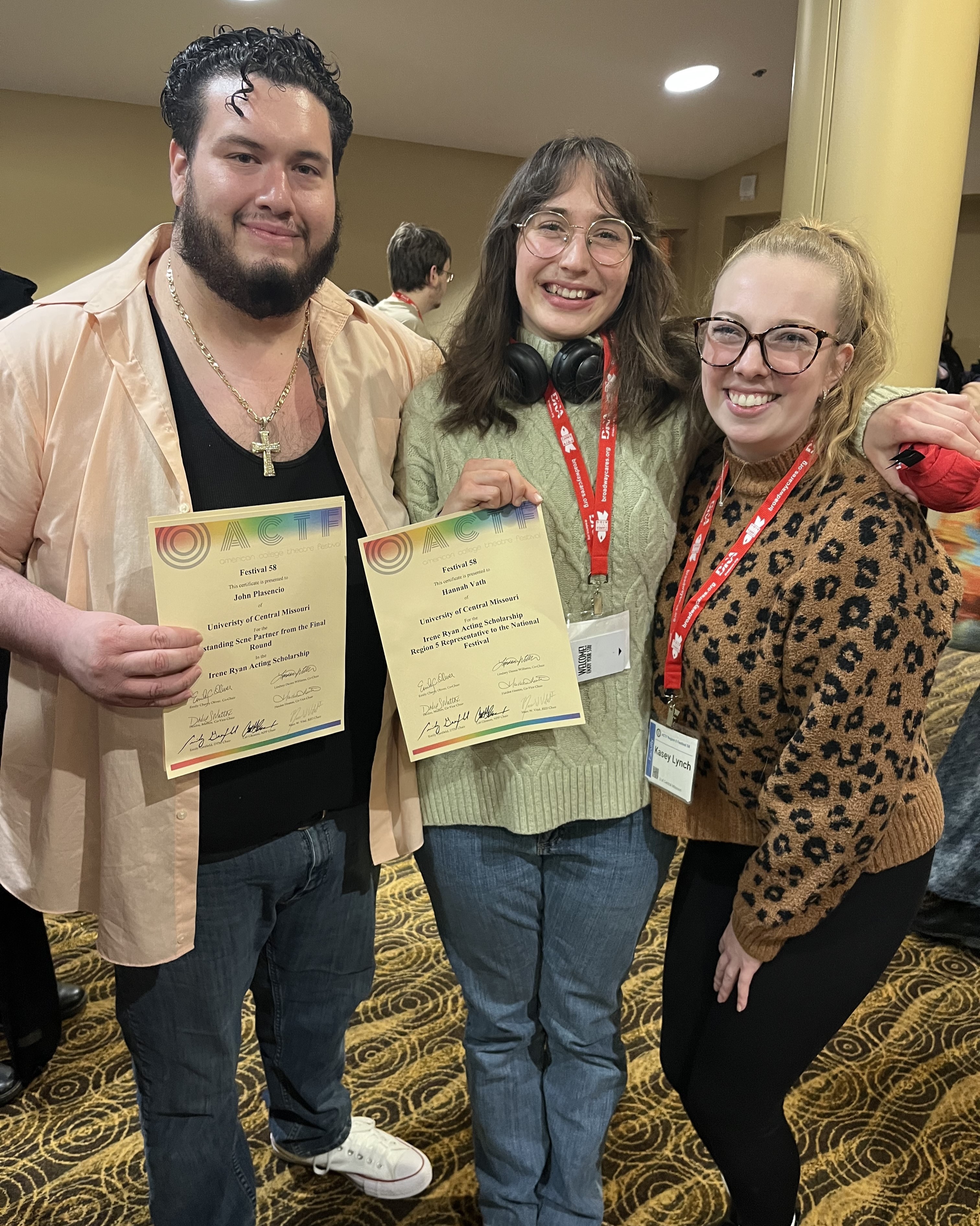 Two students and one faculty member pose with awards